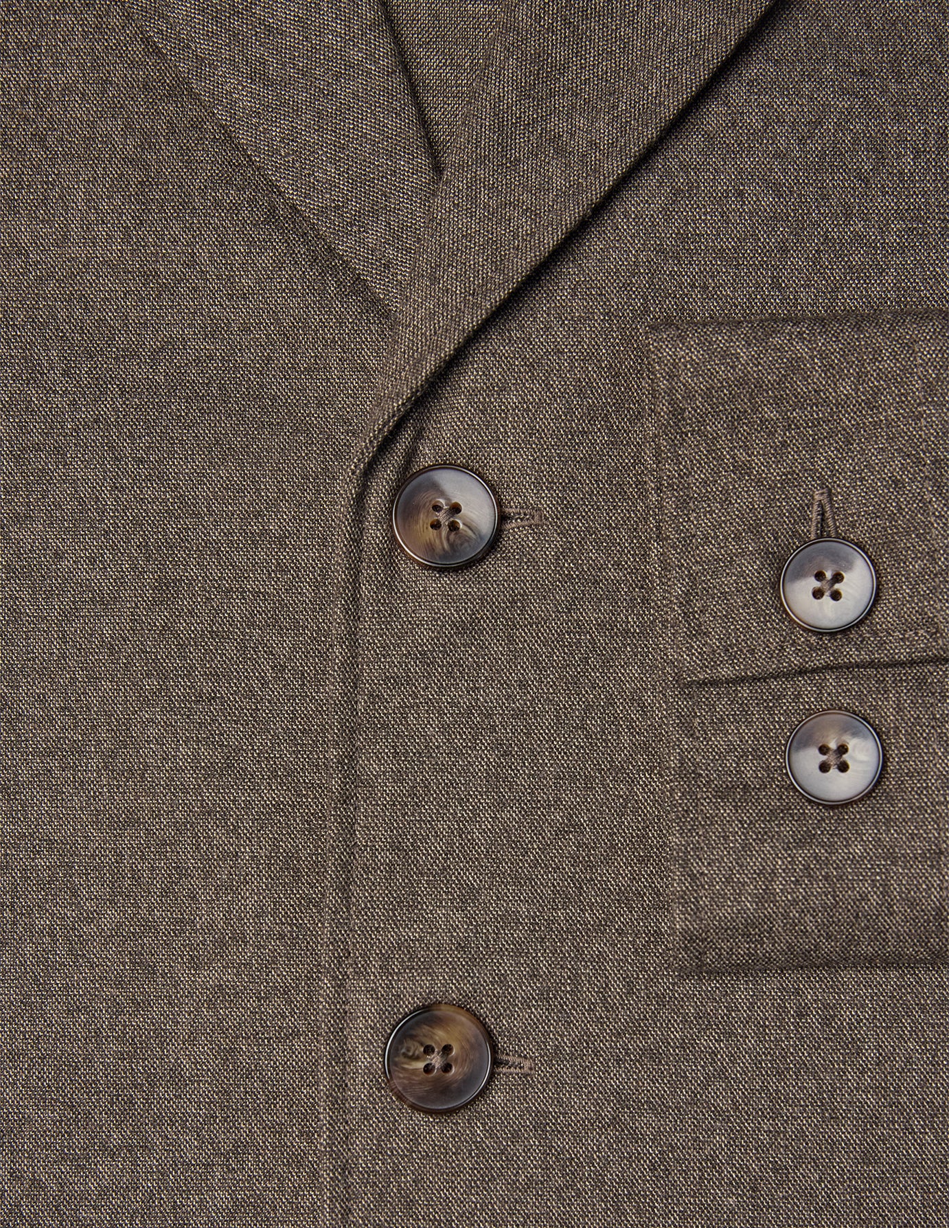 Nahaufnahme eines Atelier Overshirt in Dunkelbeige mit gebrochener Köperbindung, gekerbtem Revers, Brusttasche und dunklen Knöpfen.